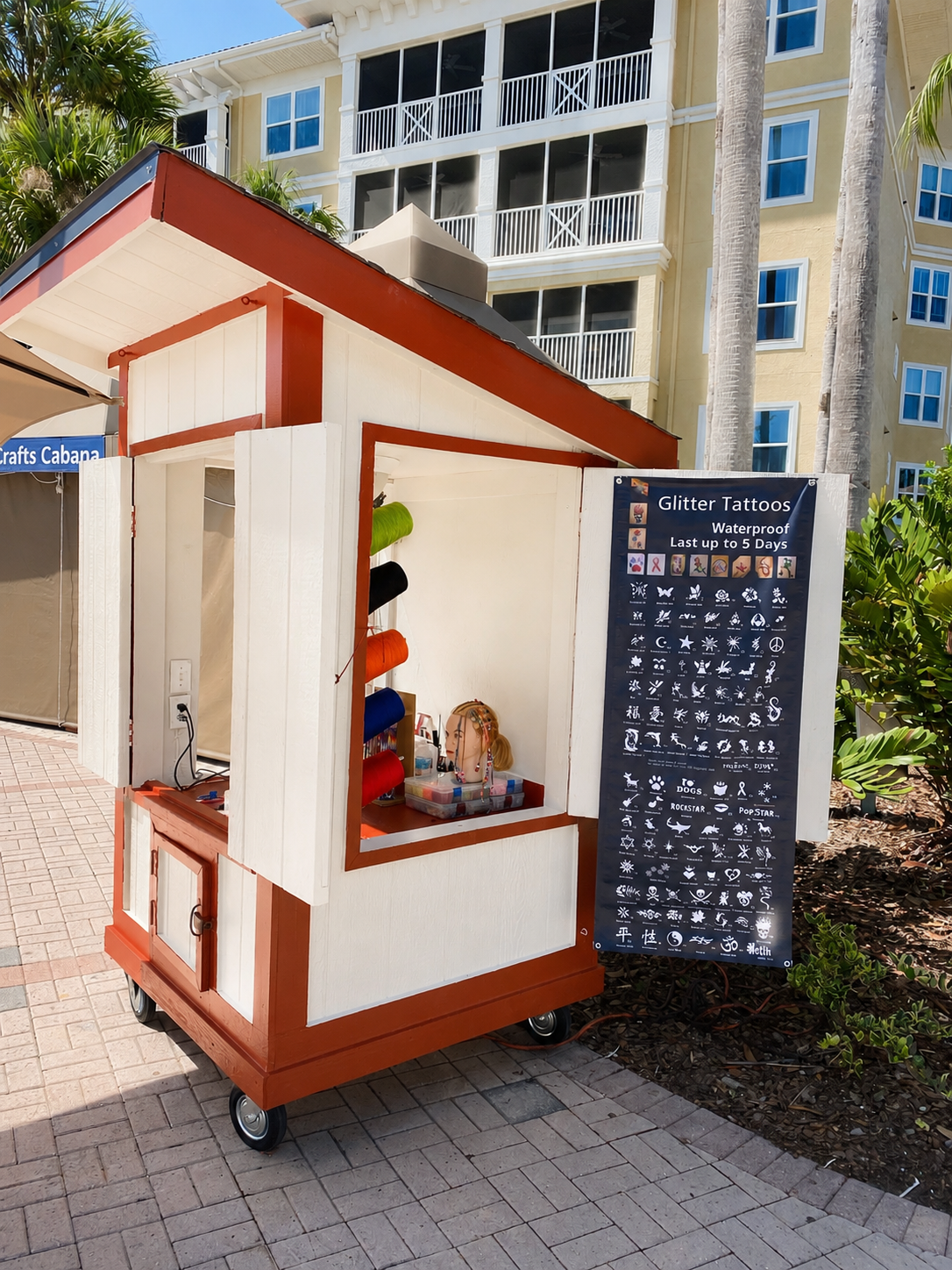 Branded Brena's Arts & Activities activity cart beside a resort crafts cabana