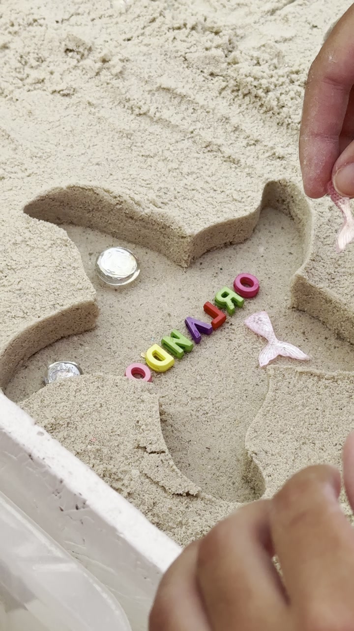 Child decorating a sand-art keepsake at a resort